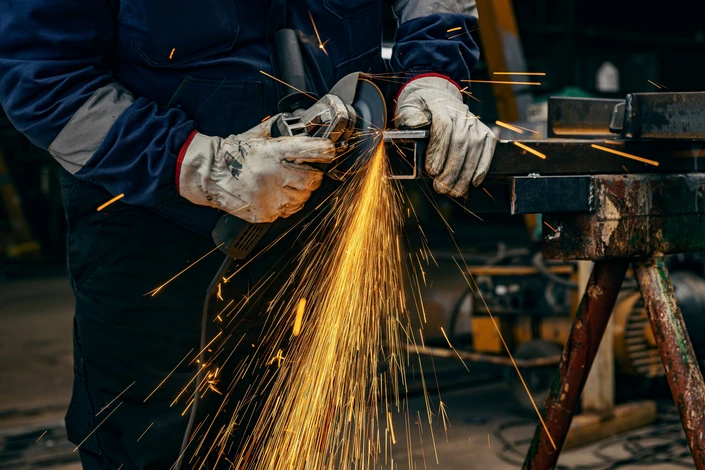 Gros plan sur les mains d'un ouvrier de l'industrie lourde mouillant dans une usine de métallurgie