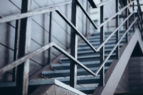 Escalier hélicoïdal moderne en bois clair avec main courante intégrée dans une architecture contemporaine aux murs blanc cassé