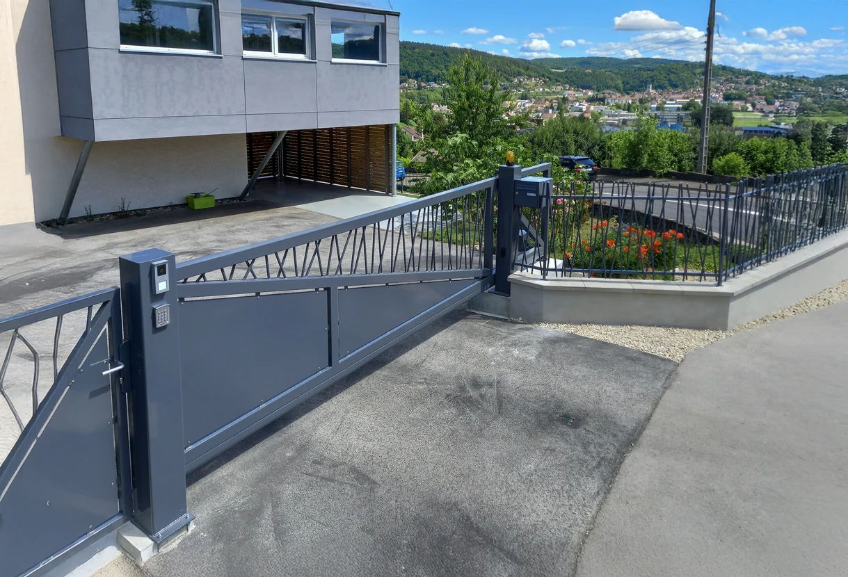 Façade extérieure de maison moderne avec mur gris clair, fenêtre circulaire distinctive au centre et porte-fenêtre à droite