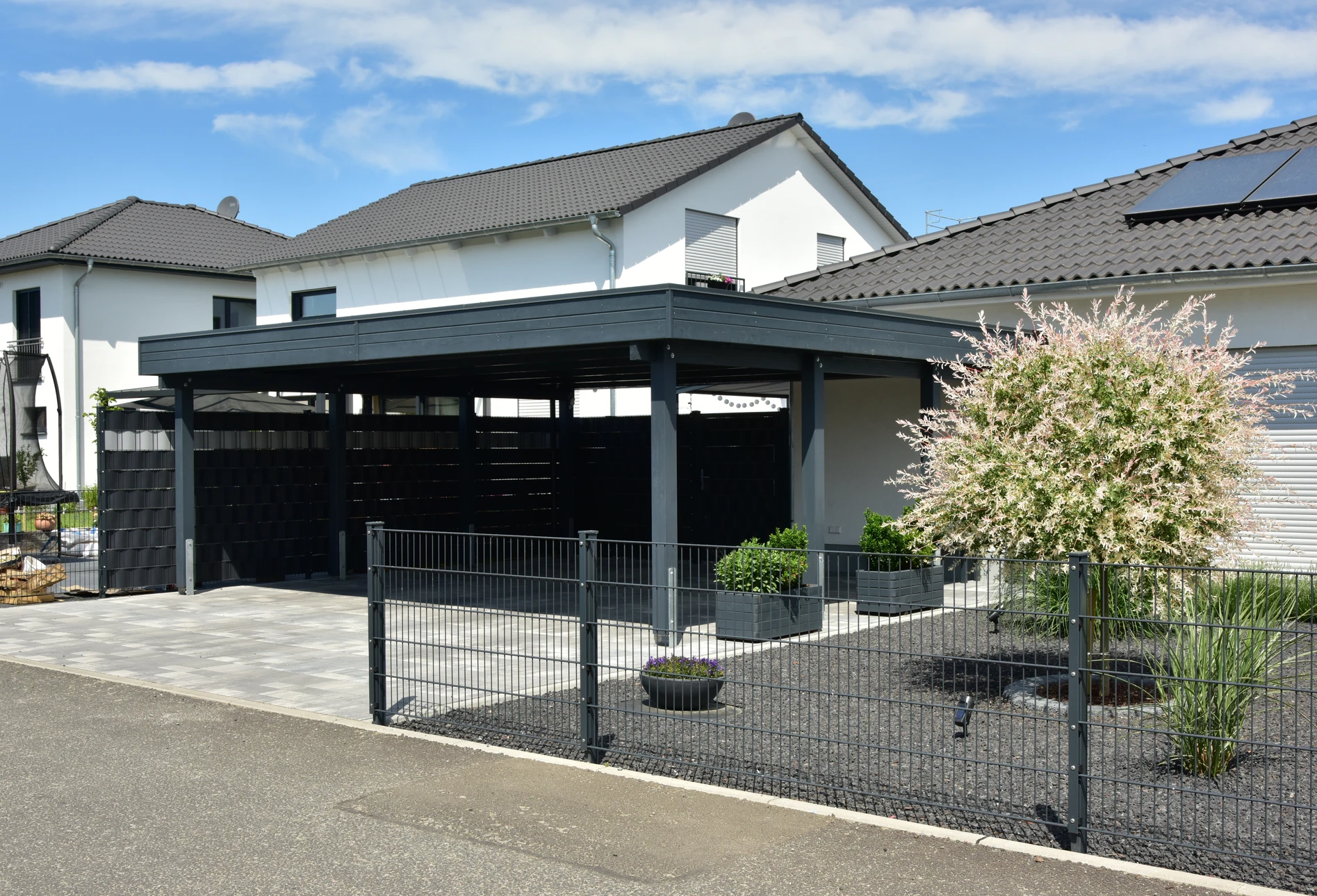 Extérieur résidentiel moderne avec véhicule blanc stationné sous carport