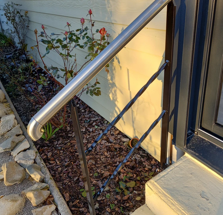 Loft industriel moderne avec mezzanine à structure métallique noire et garde-corps à câbles horizontaux