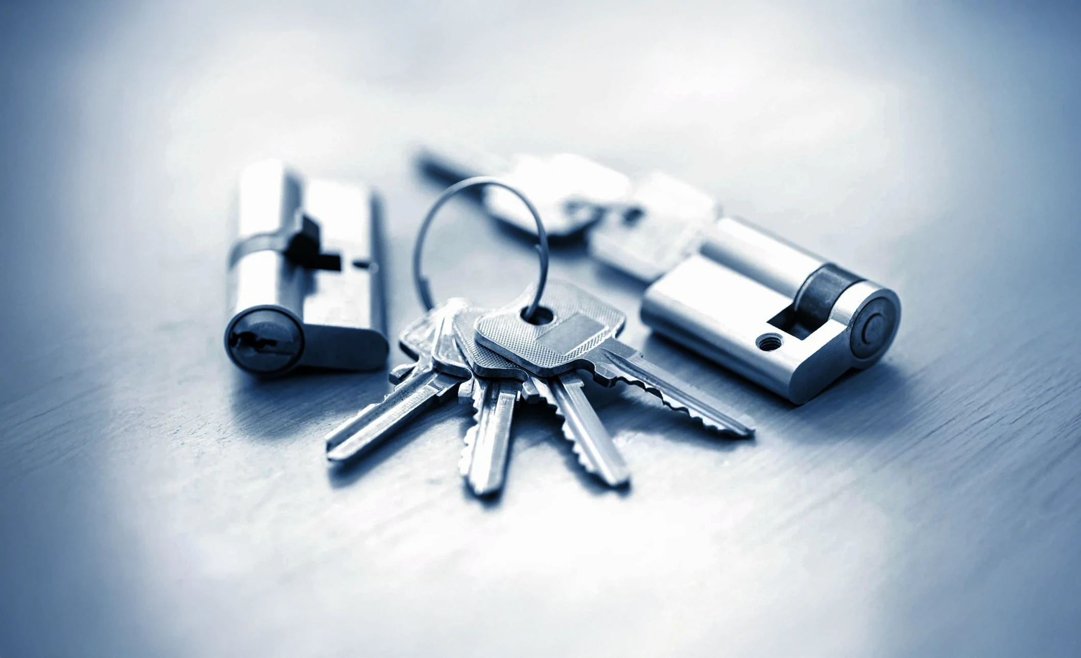 Scène d'intérieur sur surface en bois montrant des outils de serrurerie professionnelle disposés sur une table de travail