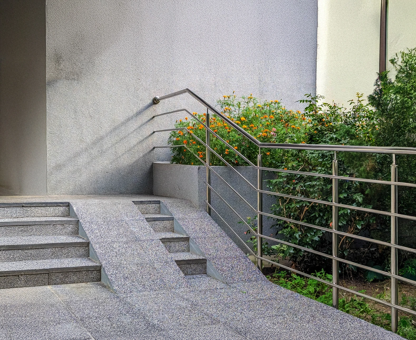 Scène intérieure d'escalier moderne avec rampe métallique chromée et marches en bois clair